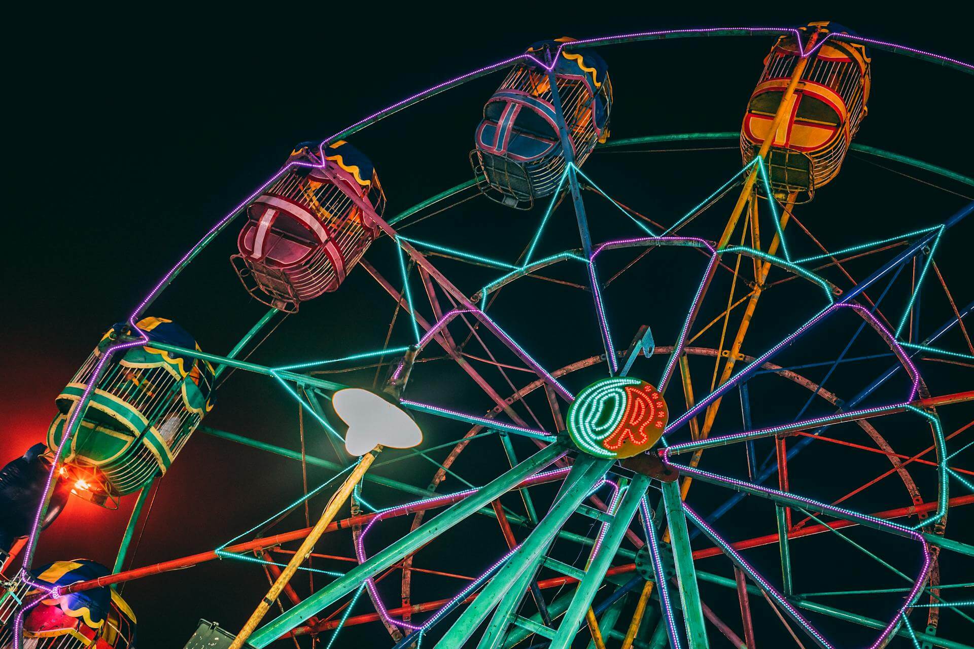 Ein bei Nacht beleuchtetes Riesenrad – das Bild steht symbolisch für die Sonderrisiken bei Carl Rieck in Düsseldorf.